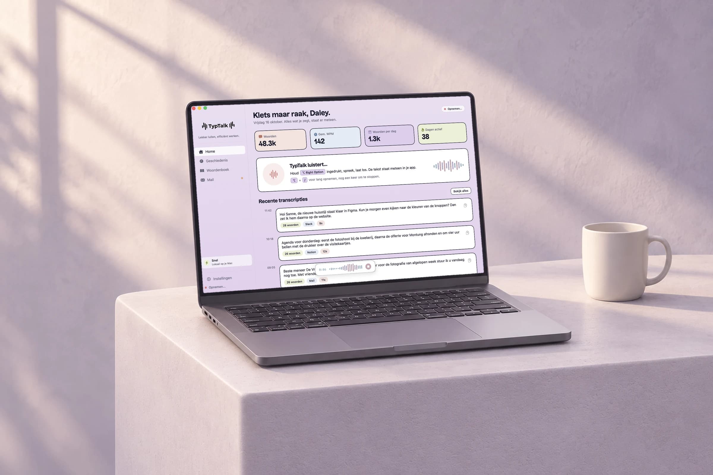 Het homescherm van TypTalk op een laptop op een lila sokkel in de zon, met een mok ernaast