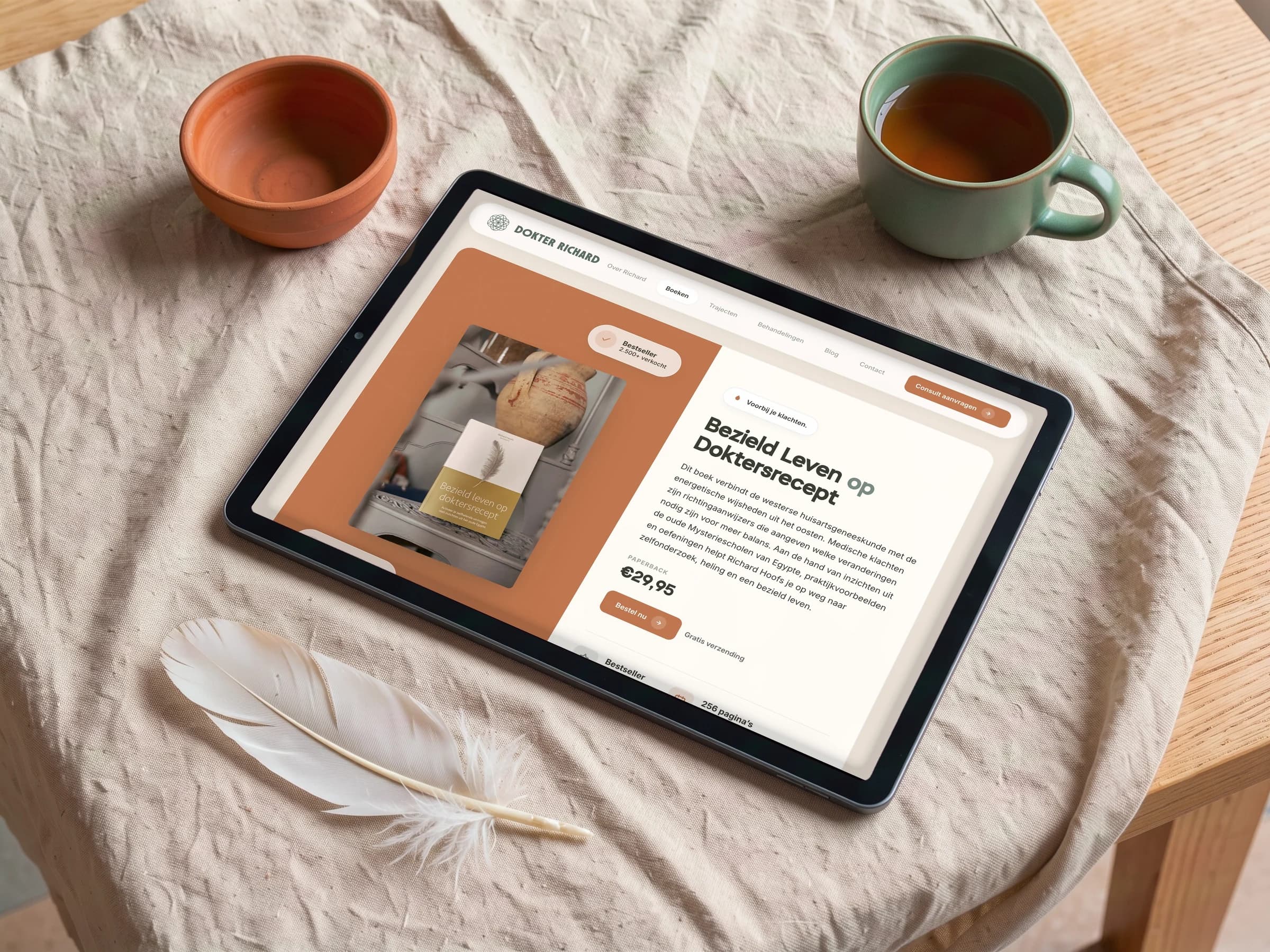 De boekenpagina van Dokter Richard op een tablet op linnen, met een veer, een kommetje en een kop thee