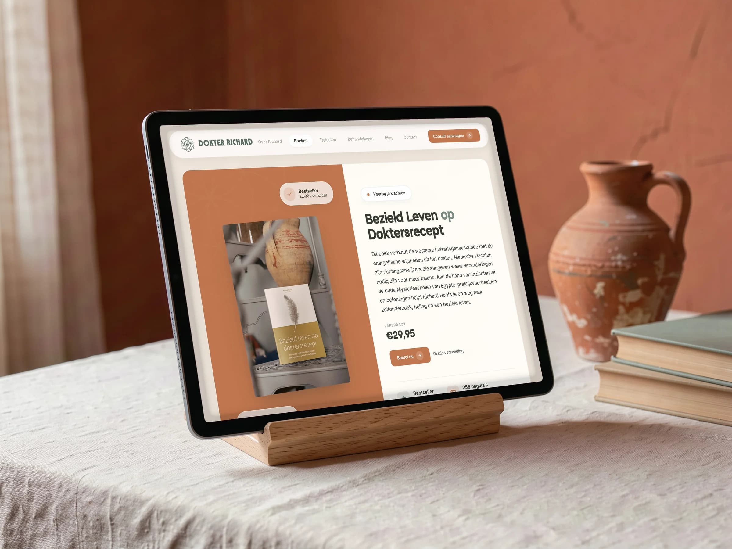 De boekenpagina van Dokter Richard op een tablet op een houten standaard, naast een terracotta kruik