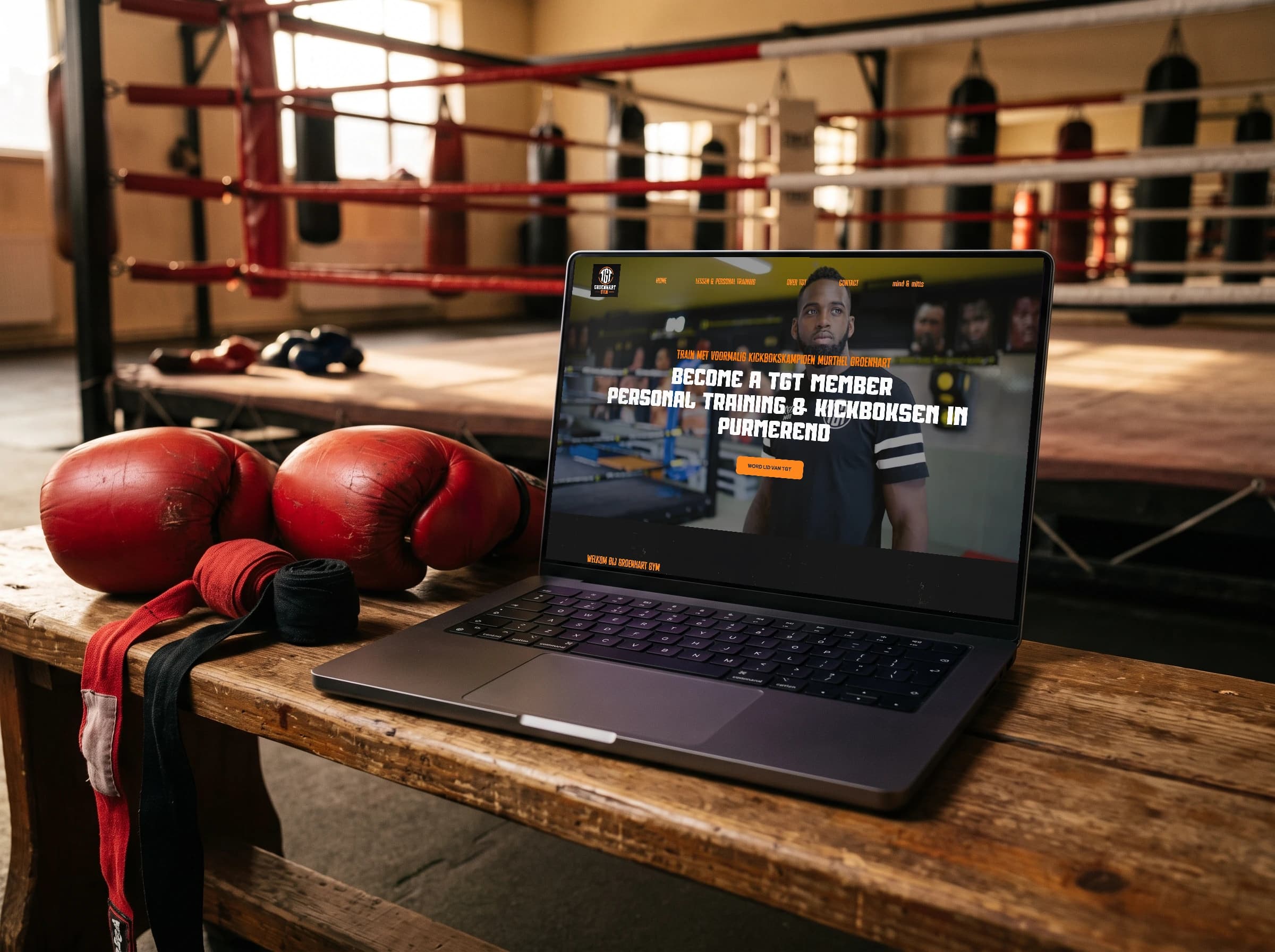 De homepage van TGT op een laptop naast bokshandschoenen in de sportschool
