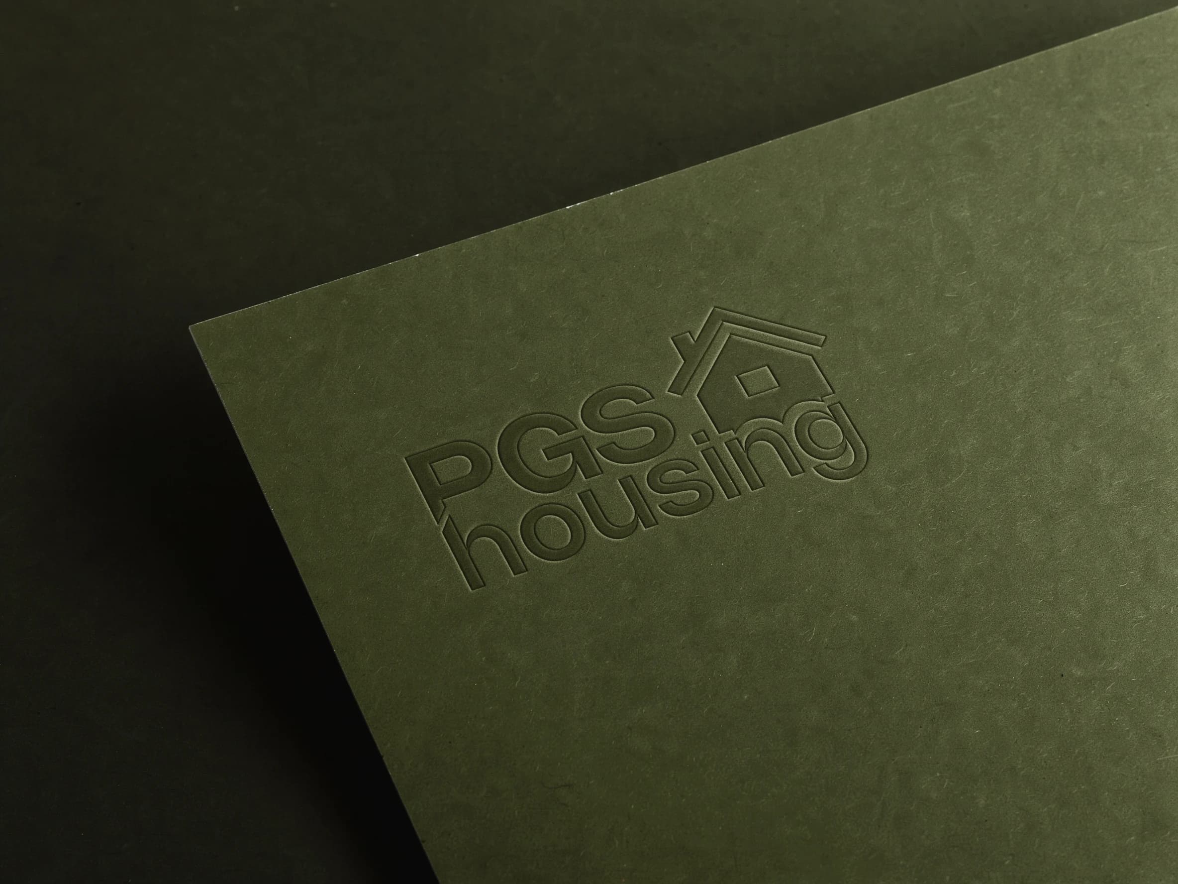 Het logo van PGS Housing in reliëf op donker olijfgroen karton