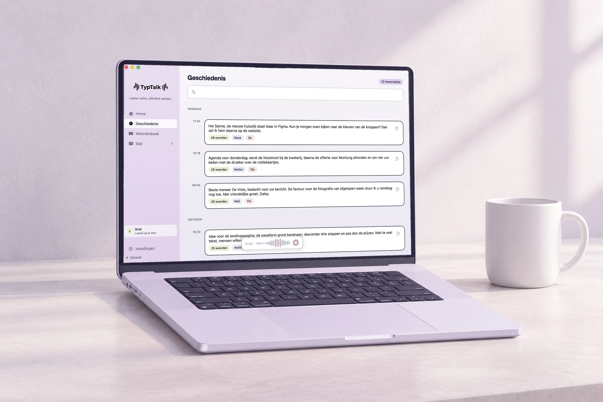 De geschiedenis van TypTalk op een laptop op een licht bureau, met het opnamepaneel en een witte mok