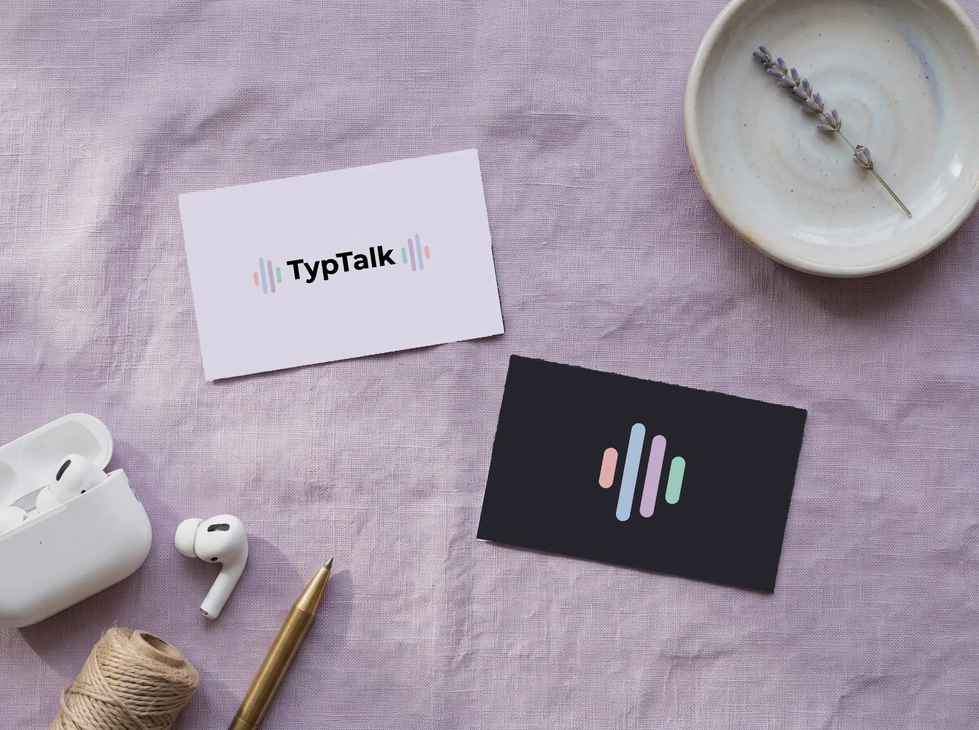 Visitekaartjes van TypTalk op lila linnen: het woordmerk op de voorkant, het beeldmerk op de donkere achterkant