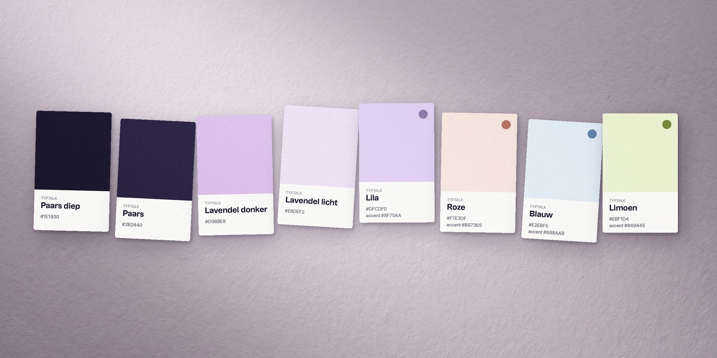 Het kleurenpalet van TypTalk als kleurstalen op lila papier: paars diep, paars, twee tinten lavendel en vier pastels met hun accentkleur